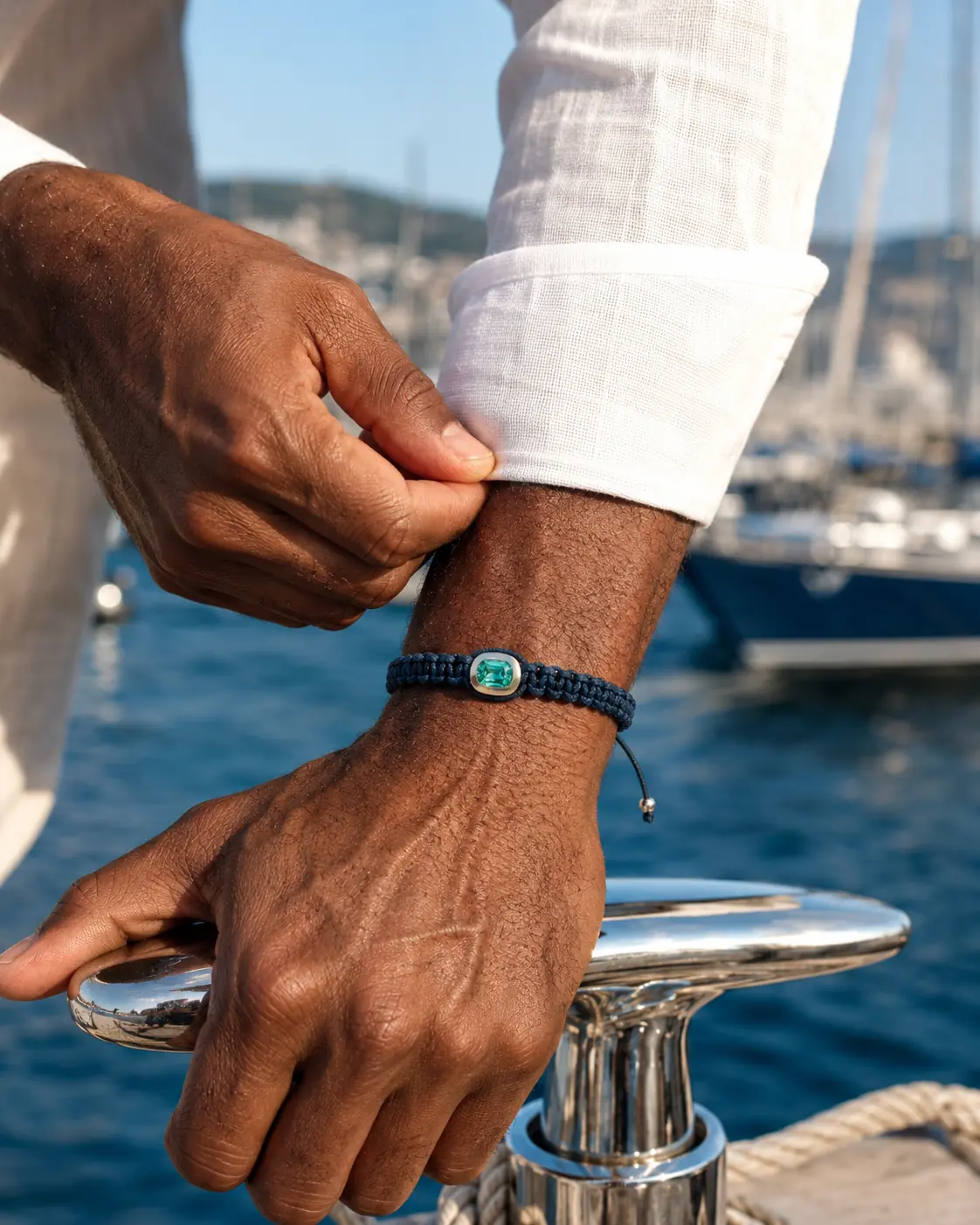 REBL Signature Bracelet worn on the wrist at a harbour, adjusting a white linen shirt cuff.
